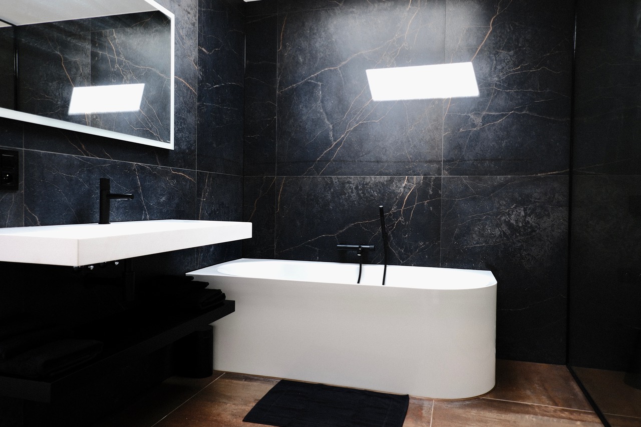 Salle de bain en marbre noir avec baignoire îlot au gîte Cit'Art
