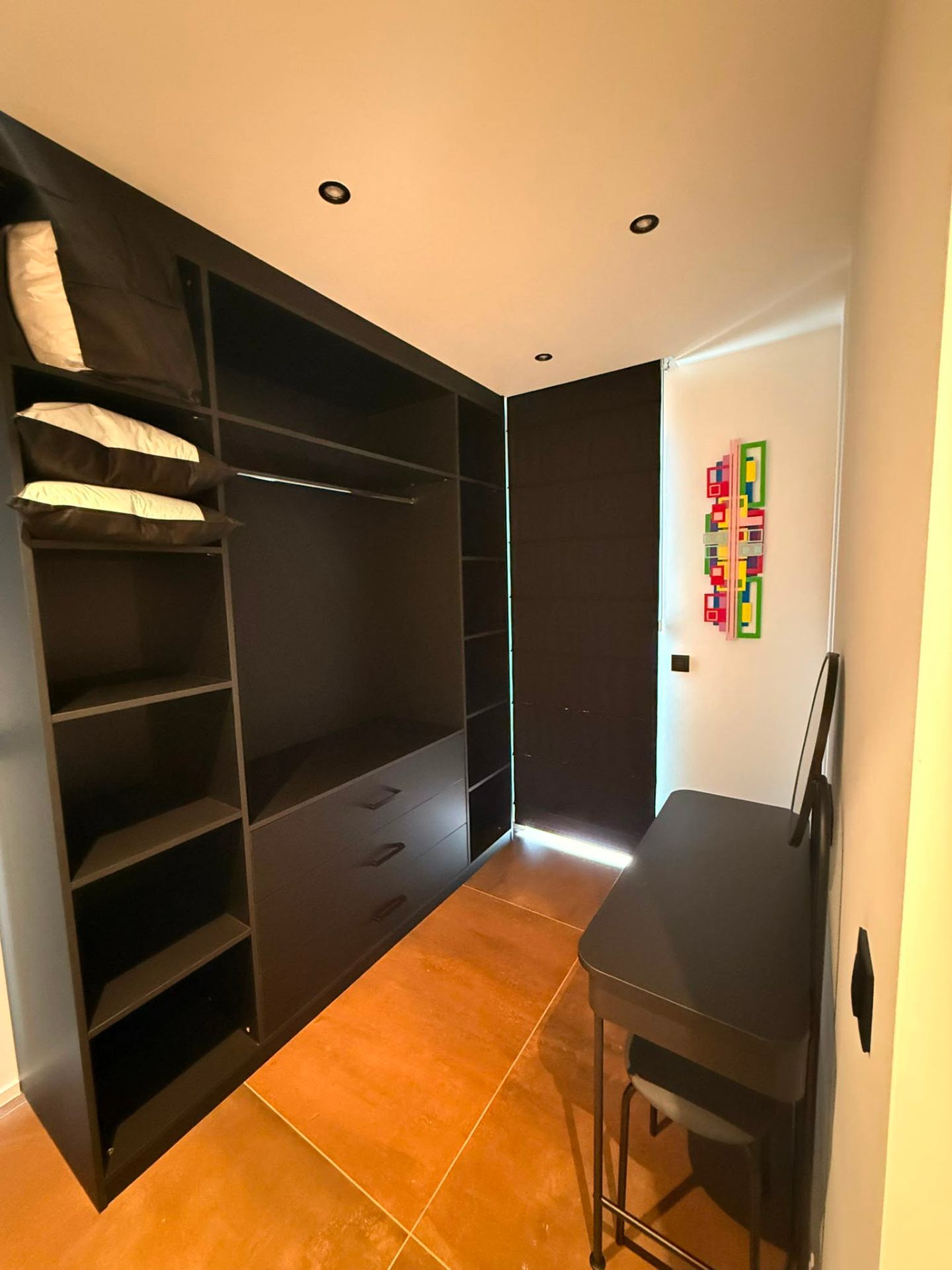 Dressing spacieux avec coiffeuse et œuvre colorée