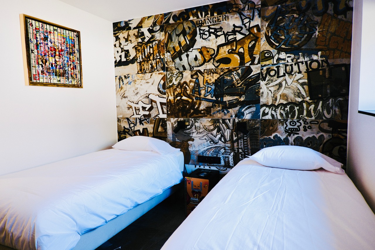 Chambre à deux lits avec mur graffiti et vitrail Pop Art au gîte Cit'Art